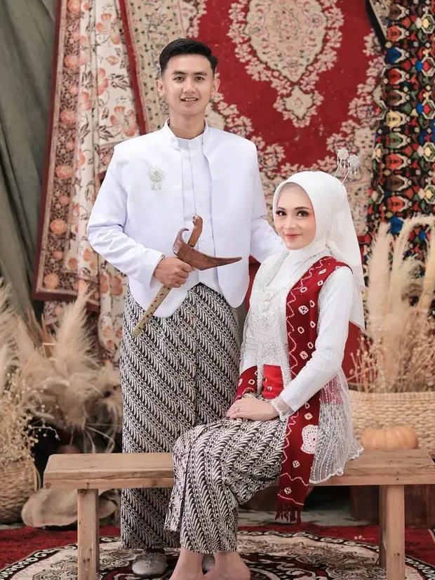 Willy dan Putri berfoto dengan busana putih dan batik parang